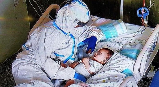 Bimbo di 7 mesi positivo al Covid coccolato da un'infermiera: la foto commuove il web