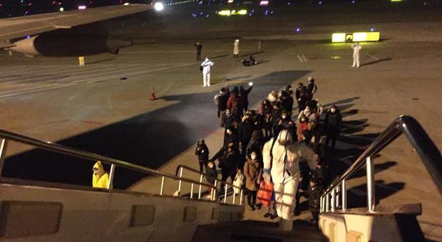 Coronavirus, gli italiani si imbarcano nell'aereo che li riporta in Italia dalla Cina: «Si torna a casa»