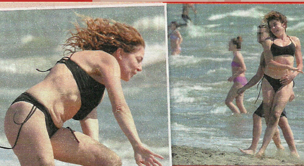 Claudia Gerini in bikini, sirenetta in spiaggia... Ma rischia il capitombolo