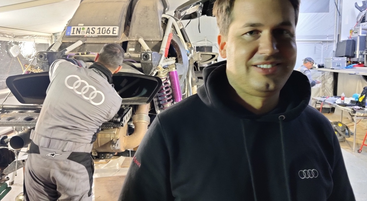 Julius Seebach, managing director di Audi Sport alla Dakar. Alle sue spalle, i meccanici lavorano alla RS Q E-tron dopo una tappa della corsa.