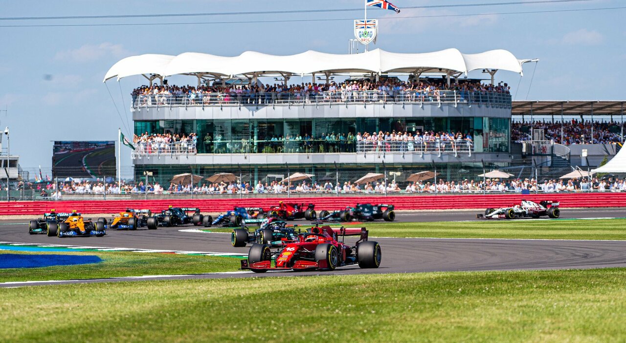La Ferrari di Leclerc in testa al gruppone con sullo sfondo le tribune piene di Silverstone