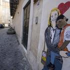 I due murales con Di Maio e Salvini che si baciano e la Meloni con un bambino africano